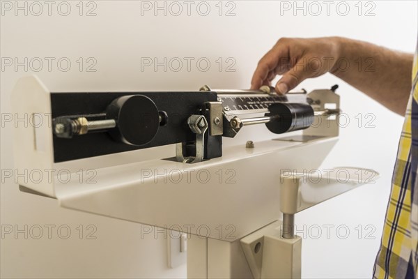 Close-up of man on weighing scale in nutritionist's office