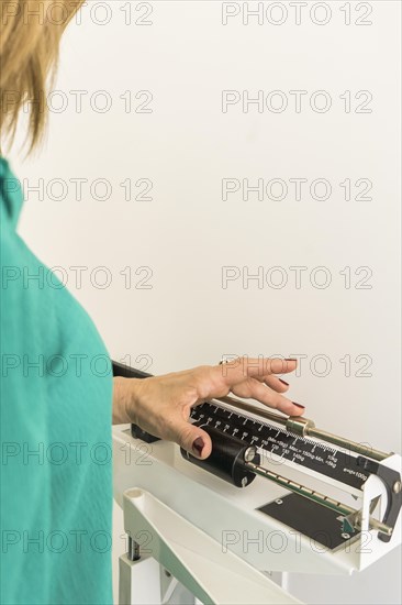Close-up of woman on weighing scale in nutritionist's office. Vertical Shot