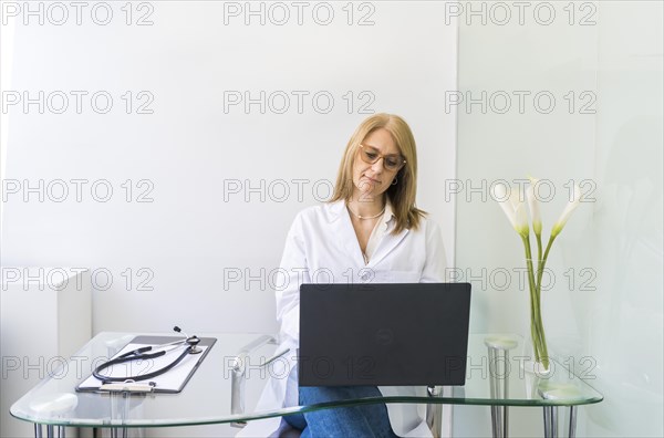 Female doctor working on laptop in medical office