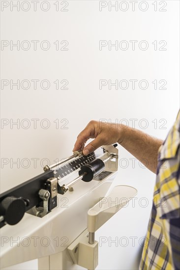 Close-up of man on weighing scale in nutritionist's office. Vertical Shot. Copy space