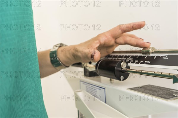 Close-up of woman on weighing scale in nutritionist's office