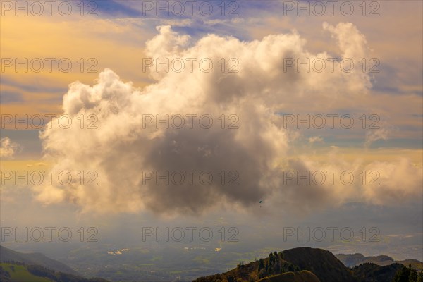 Aerial View over Beautiful Mountainscape with Floating Clouds and a Paraglider Flying with Sunlight From Monte Generoso