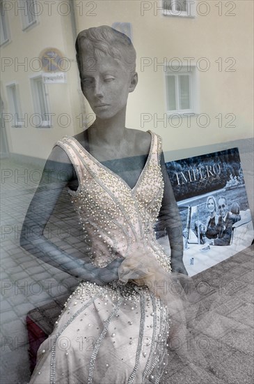 Shop window with fashion mannequin in evening dress
