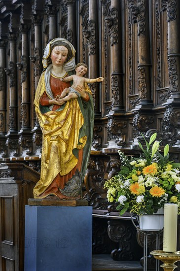 Figure of the Virgin Mary with baby Jesus and floral decoration