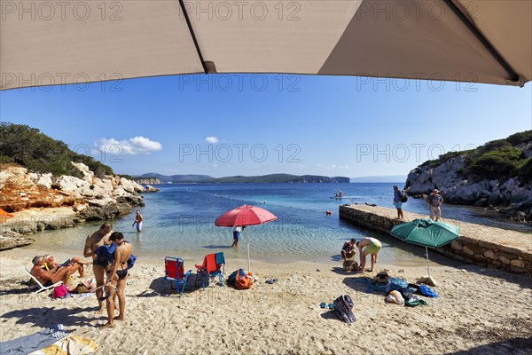 Small family beach Cala Dragunara with tourists