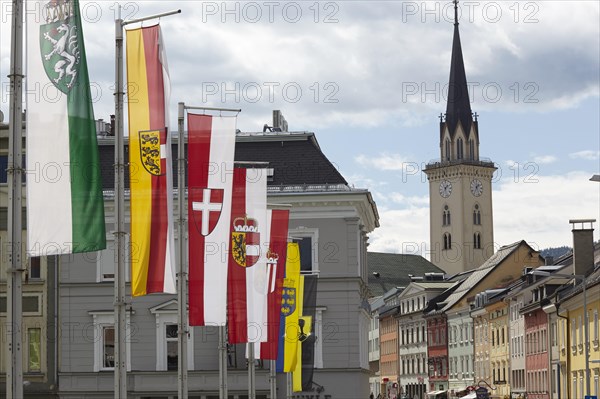 Flags on the Drau bridge with parish church