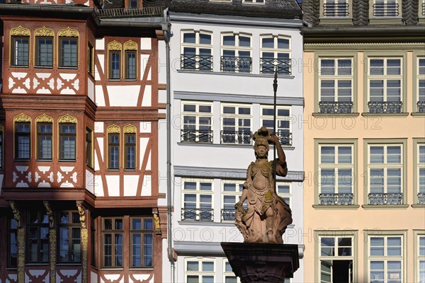 Fountain representing roman goddess Minerva in front of colorful Half-timbered houses in Roemerberg square