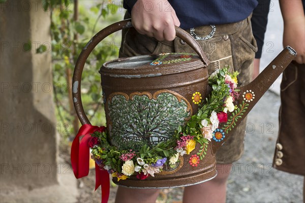 Decorated watering can with the motif of a dancing lime tree for the historic dancing lime tree festival in Limmersdorf