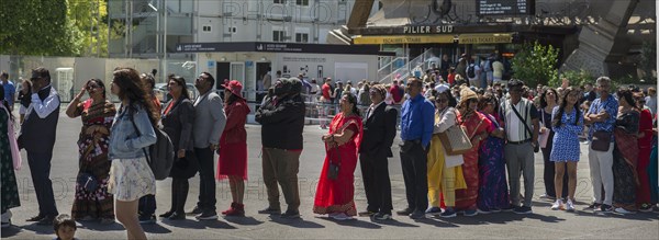 Tourists waiting in front of the entrance to the Eiffel Tower