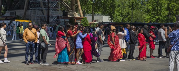 Tourists with colourful robes waiting in front of the entrance to the Eiffel Tower