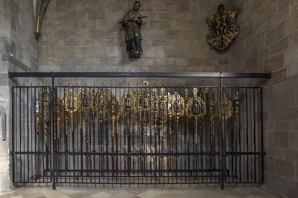 Richly decorated processional poles secured by a grille