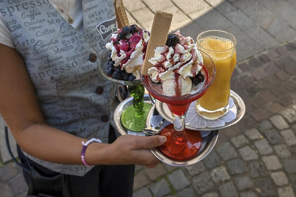 Waitress brings ice cream and drinks to a table