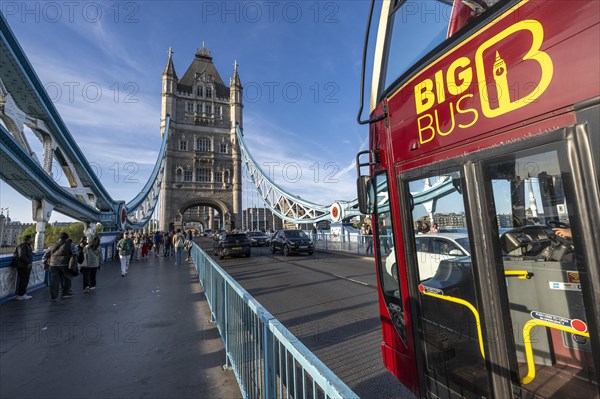 Red double-decker bus drives over Tower Bridge in London