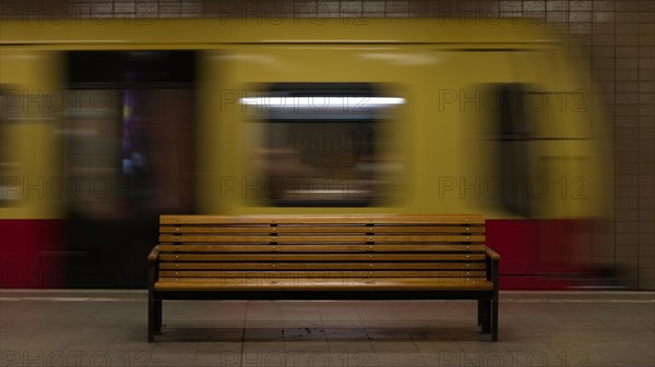 Wooden bench and departing train at Nordbahnhof