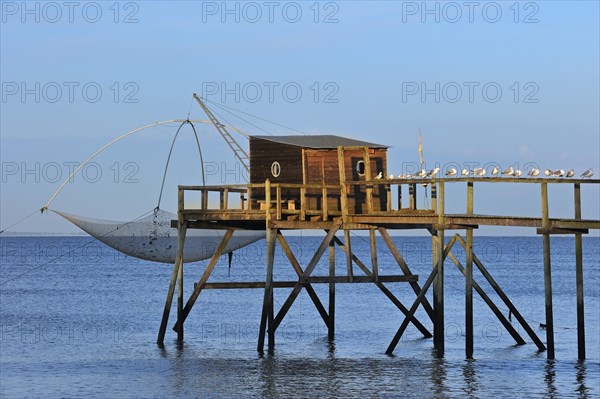 Traditional carrelet fishing hut with lift net on the beach