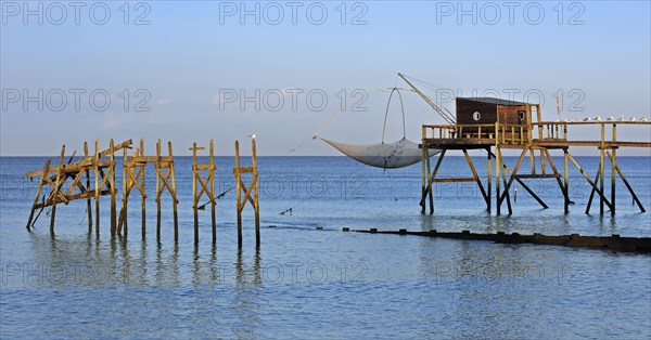 Traditional carrelet fishing hut with lift net on the beach