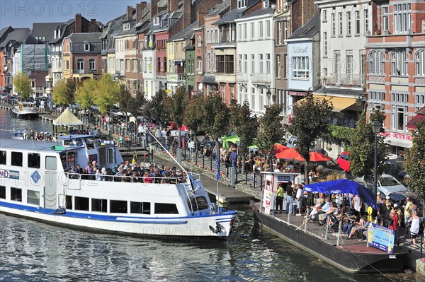 Tourists on sightseeing trip by pleasure boat on the river Meuse at Dinant