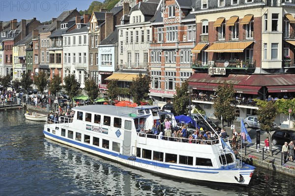 Tourists on sightseeing trip by pleasure boat on the river Meuse at Dinant