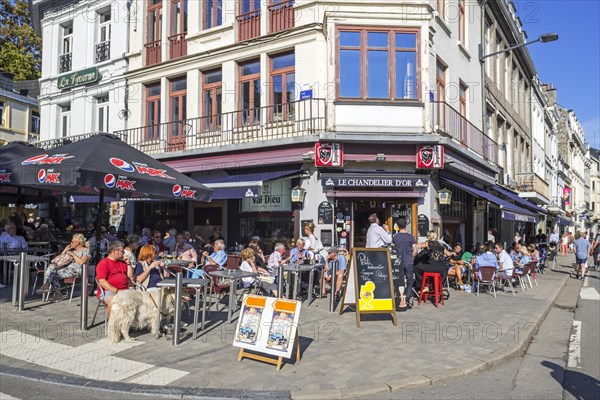 Tourists enjoying Belgian beer on pavement cafe in summer in the city Spa