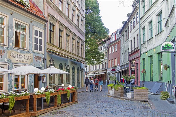 Cobbled street with restaurants and cafes in the historic city centre of Riga