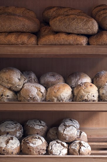 Shelves with loaves of fresh baked bread on display in bakery