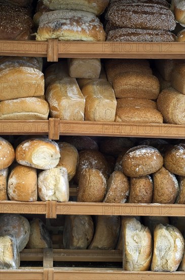 Shelves with loaves of fresh baked bread on display in bakery