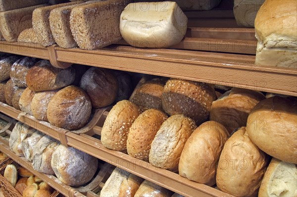 Shelves with loaves of fresh baked bread on display in bakery