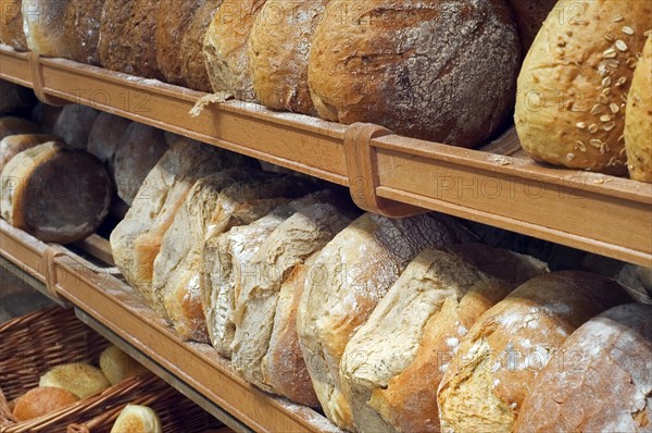 Shelves with loaves of fresh baked bread on display in bakery