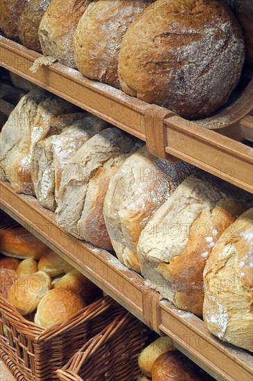 Shelves with loaves of fresh baked bread on display in bakery