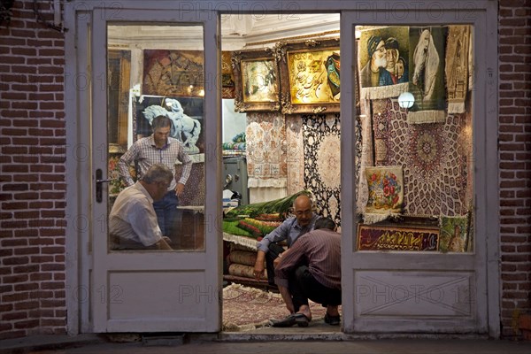Men selling carpets in carpet store in the old historic bazaar of the city Tabriz