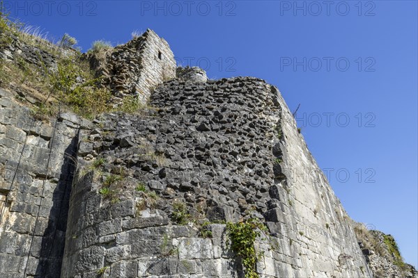 Thick stone wall of medieval castle showing two types of masonry
