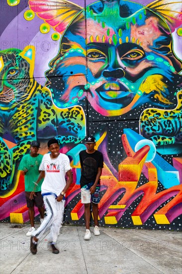 Breakdancing in front of graffiti on the wall of a house