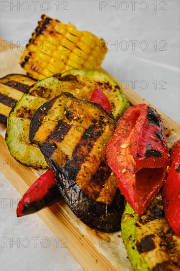 Close up view of grilled vegetables on wooden serving board