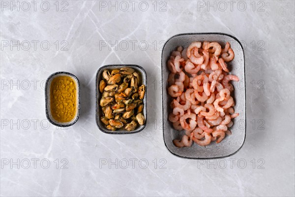 Top view of bowls with peeled shrimps