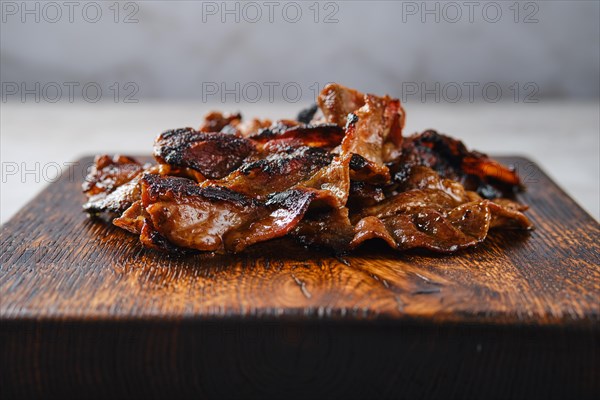 Closeup view of serving board with fried beef bacon strips