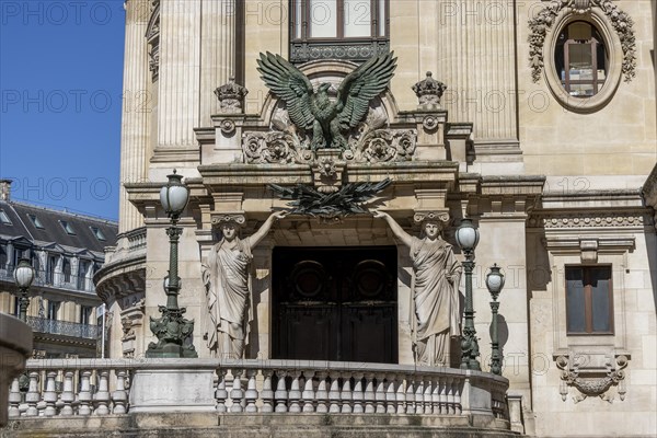 The opulent entrance to the Palais Garnier opera house with caryatids and a large eagle sculpture above the door