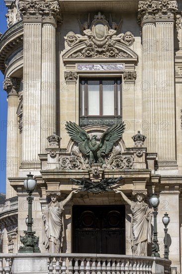 The opulent entrance to the Palais Garnier opera house with caryatids and a large eagle sculpture above the door