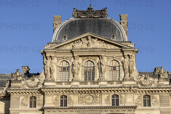 Detail of the opulent Louvre Museum building with sculptures on top