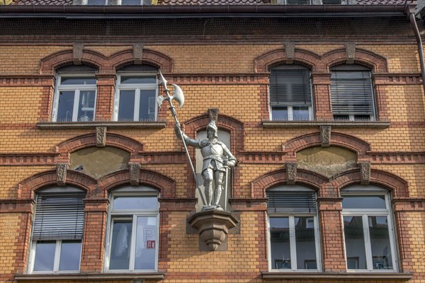 Knightly sculpture on the red brick facade of a building in Bahnhofstrasse