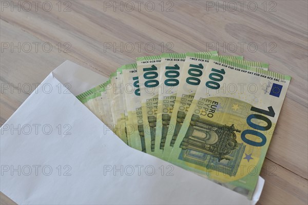 Many one hundred euro notes in an envelope on a table
