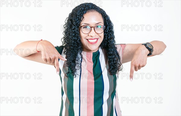 Happy afro young woman pointing at advertising down isolated. Smiling latin woman pointing and looking down