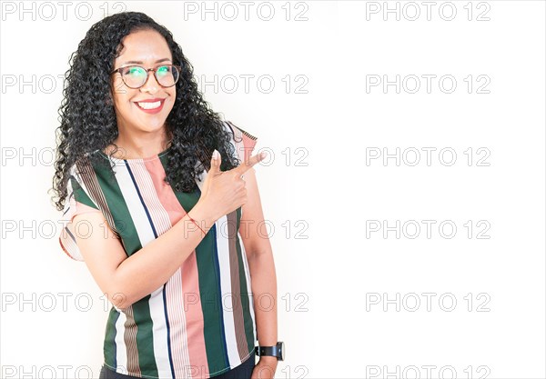 Smiling afro young woman pointing an advertising isolated. Beautiful afro girl pointing to a banner to the side. Happy people pointing a promo isolated