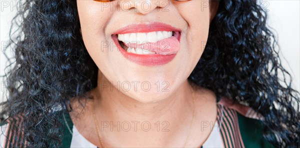 Close up of Girl mouth biting her tongue isolated. Close up of sexy girl biting tongue