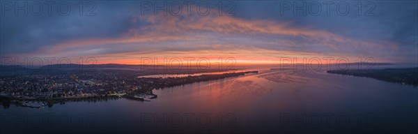 Aerial panorama of western Lake Constance in front of sunrise with the town of Radolfzell and the Mettnau peninsula