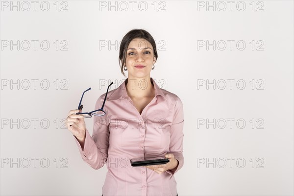 Studio portrait of a young blonde business woman holding a tablet and glasses. White background. Copy space