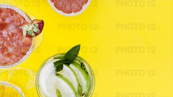 Glasses with strawberry lime cocktails yellow background