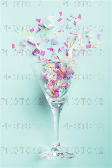 Glass with confetti turquoise background