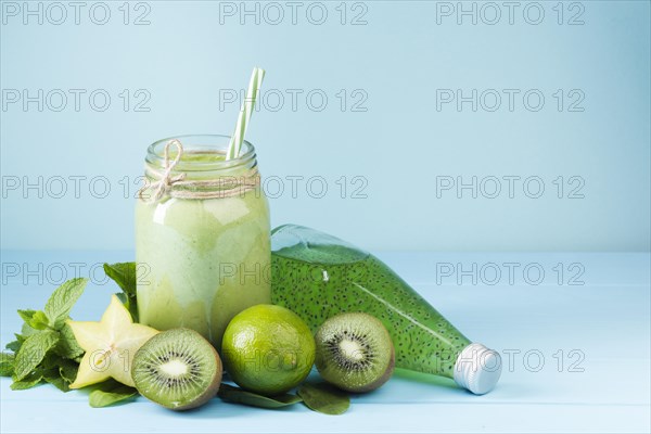 Green fruit smoothie juice blue background