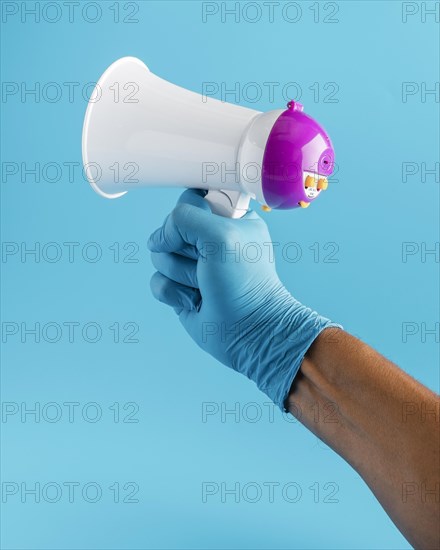 Hand with glove holding megaphone