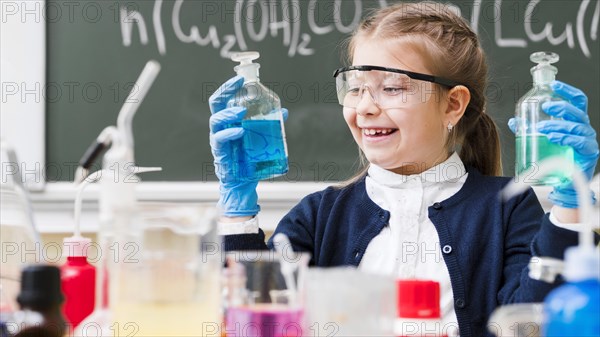 Happy girl with goggles holding flasks